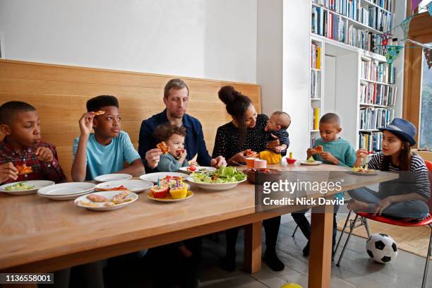 Large multi ethnic family having food at kitchen table