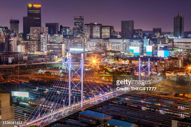 das stadtbild von johannesburg mit der nelson-mandela-brücke - african cityscape stock-fotos und bilder