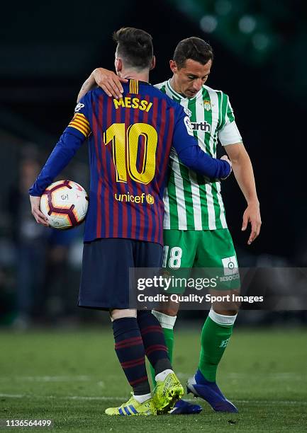 Lionel Messi of FC Barcelona and Andres Guardado of Real Betis look on after the victory of the La Liga match between Real Betis Balompie and FC...