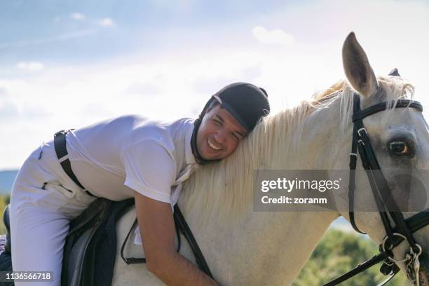 man in the saddle leaning happily on the horse - jockey uniform stock pictures, royalty-free photos & images