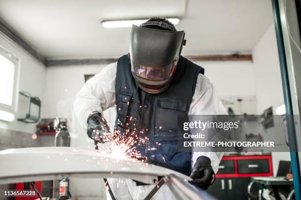 body repair technician using a mig welder to repair a damaged car part in a body shop - mig welder stock pictures, royalty-free photos & images