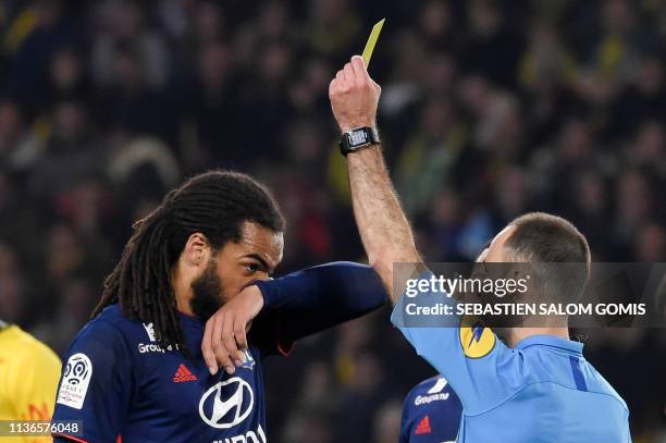 Lyon's Belgian defender Jason Denayer is shown a yellow card during the French L1 football match between FC Nantes and Olympique Lyonnais at the La...