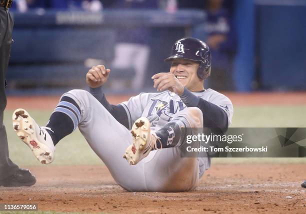 Avisail Garcia of the Tampa Bay Rays reacts after sliding across home plate to score a run on an RBI triple by Kevin Kiermaier in the third inning...