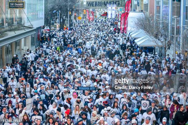 Fans pack the streets during the Whiteout Street Party prior to NHL action between the Winnipeg Jets and the St. Louis Blues in Game Two of the...