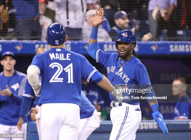 Luke Maile of the Toronto Blue Jays is congratulated by Alen Hanson after hitting a two-run home run in the seventh inning during MLB game action...