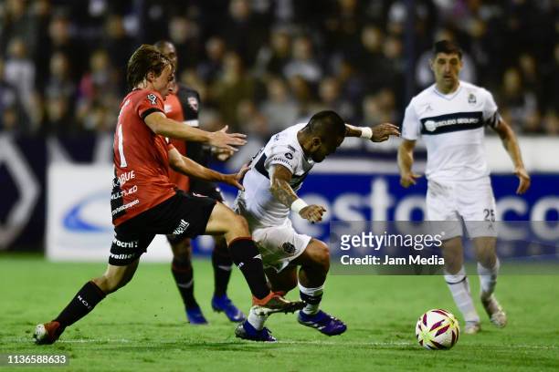 Victor Ayala of Gimnasia y Esgrima controls the ball under pressure from Jeronimo Cacciabue of Newell's All Boys during a during a match between...