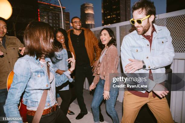 friends have fun on downtown los angeles rooftop - rooftop party night stock pictures, royalty-free photos & images