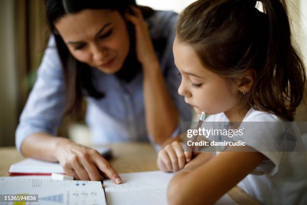 mother helping daughter with homework - guidance stock pictures, royalty-free photos & images