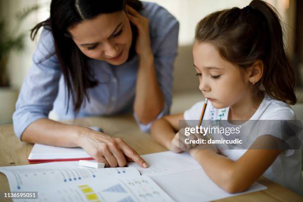 mother and daughter working homework together - learning difficulty stock pictures, royalty-free photos & images