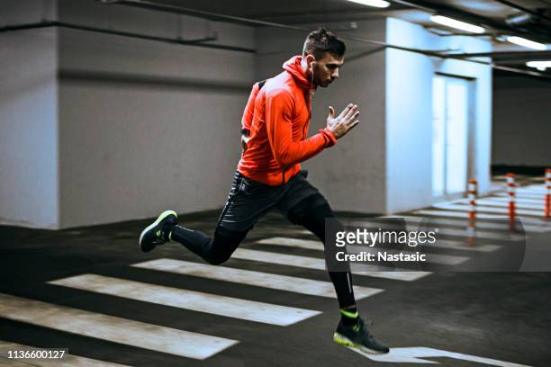 young runner running trough city - sprinter stock pictures, royalty-free photos & images