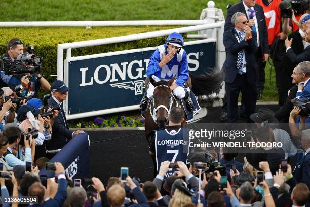 Jockey Hugh Bowman celebrates on the back of champion race horse Winx after her final race to victory in the Longines Queen Elizabeth Stakes during...