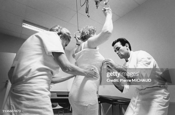 Pose d'un plâtre autours du corps d'une patiente aux urgences de l'hôpital de la Croix Saint-Simon, à Paris, en 1989, France.