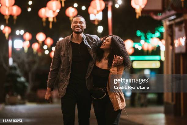 happy couple exploring chinatown in downtown los angeles at night - downtown los angeles stock pictures, royalty-free photos & images