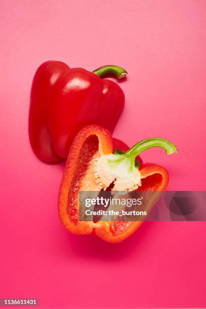 still life of sliced red bell peppers on pink background - bell pepper stock-fotos und bilder