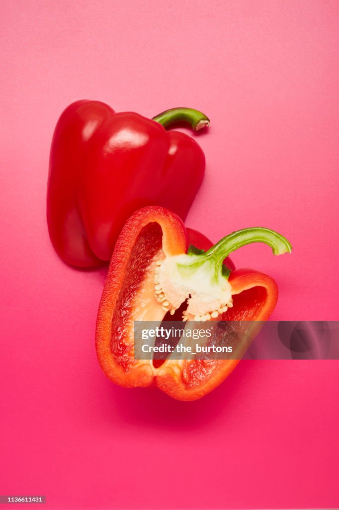 Still life of sliced red bell peppers on pink background