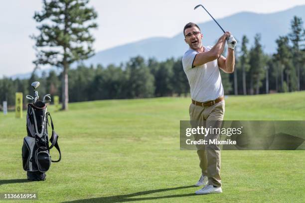 adult male golfer teeing off - golf swing stock pictures, royalty-free photos & images