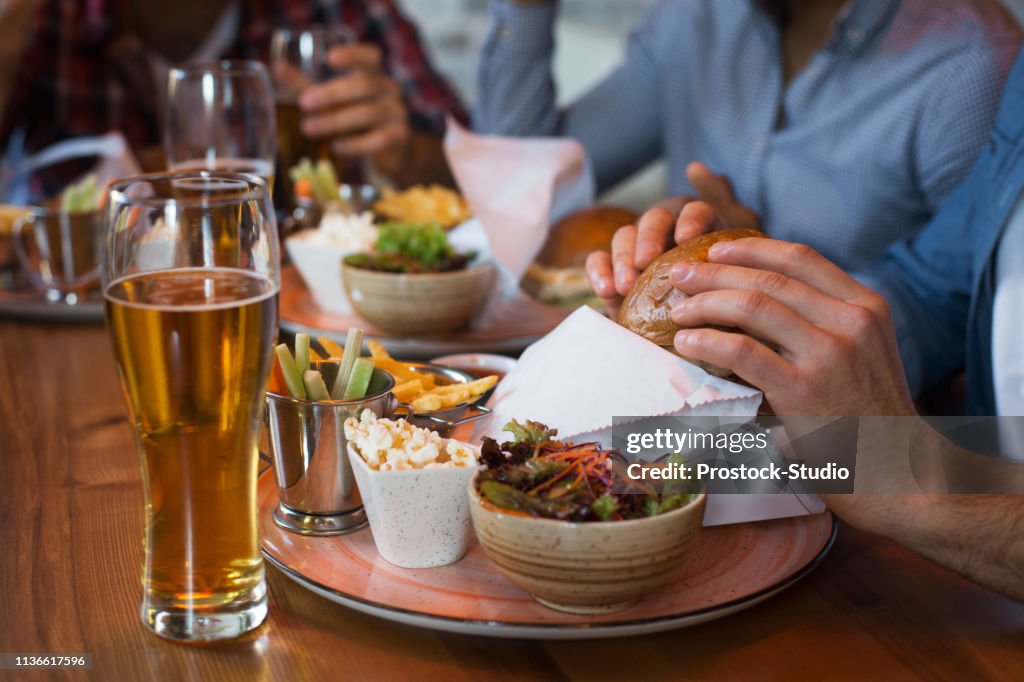 Friends enjoying beer and burgers in bar