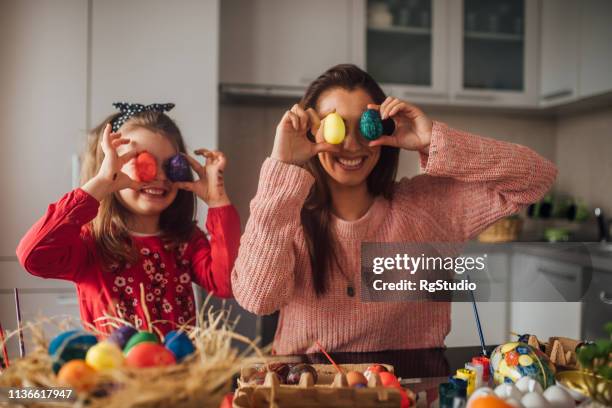 familie mit bunten ostereiern - easter eggs stock-fotos und bilder