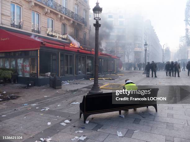 Manifestants et force de l'ordre devant la vitrine brisée du restaurant le Fouquet's lors de la manifestation de l'acte 18 des "Gilets Jaunes" le 16...