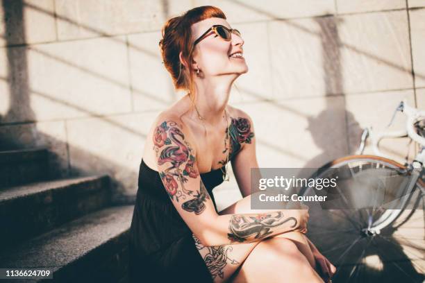 woman smiling in sunshine with ring on necklace - tattoo stock-fotos und bilder