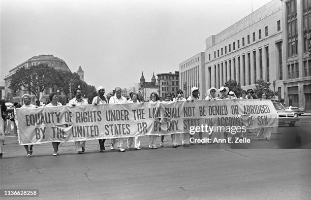 View of demonstrators as they carry a banner on Pennsylvania Avenue during the Equal Rights Amendment March, Washington DC, July 9, 1978. Their...