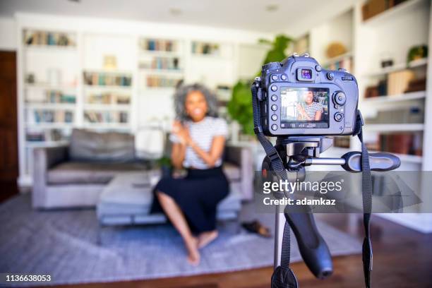 beautiful black woman recording a video - photo shoot at home stock pictures, royalty-free photos & images