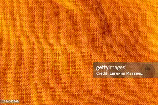 the texture of crumpled cotton linen carrot orange red color fabric texture background - toile matière photos et images de collection