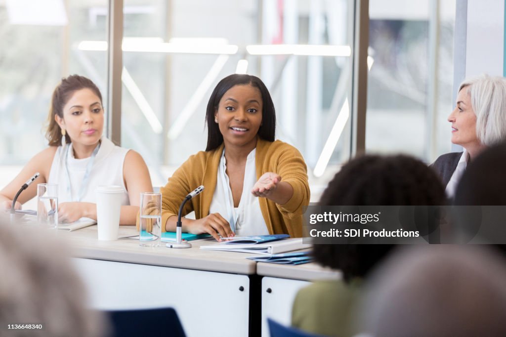 Businesswoman gestures during panel discussion