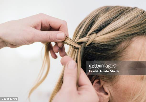 make-up artist doing hair. - trenzado fotografías e imágenes de stock
