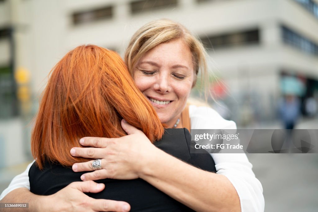 Mother and Daughter embracing on the city