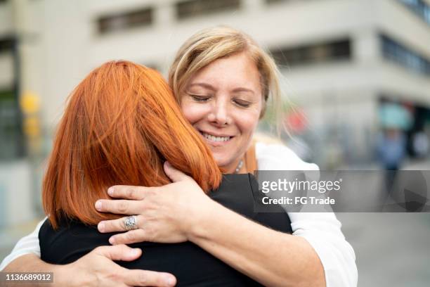 mother and daughter embracing on the city - apology stock pictures, royalty-free photos & images