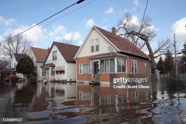 Homes are surrounded by floodwater from the Pecatonica River on March 18, 2019 in Freeport, Illinois. Several Midwest states are battling some of the...