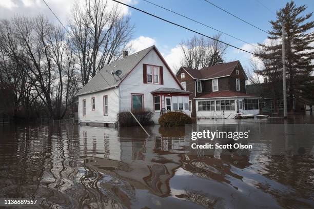 Homes are surrounded by floodwater from the Pecatonica River on March 18, 2019 in Freeport, Illinois. Several Midwest states are battling some of the...