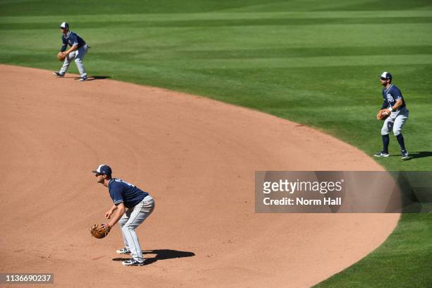 Wil Myers, Luis Urias and Greg Garcia of the San Diego Padres shift to the right side of the infield during the fifth inning of a spring training...