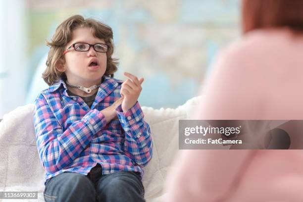 el terapeuta y el chico que es sordo firmando entre sí - american sign language fotografías e imágenes de stock