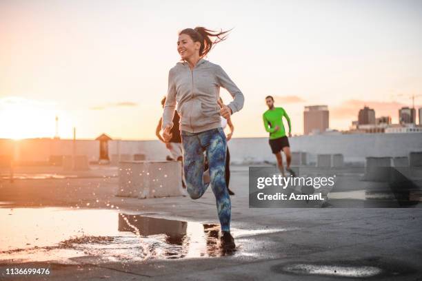 vrienden joggen samen op het terras tegen de hemel - california strong stockfoto's en -beelden