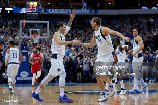 Dirk Nowitzki of the Dallas Mavericks celebrates with Luka Doncic of the Dallas Mavericks after scoring a basket against Kenrich Williams of the New...