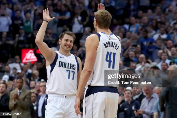 Dirk Nowitzki of the Dallas Mavericks celebrates with Luka Doncic of the Dallas Mavericks after scoring a basket against Kenrich Williams of the New...