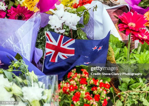 flag and flowers in support - christchurch new zealand stock pictures, royalty-free photos & images