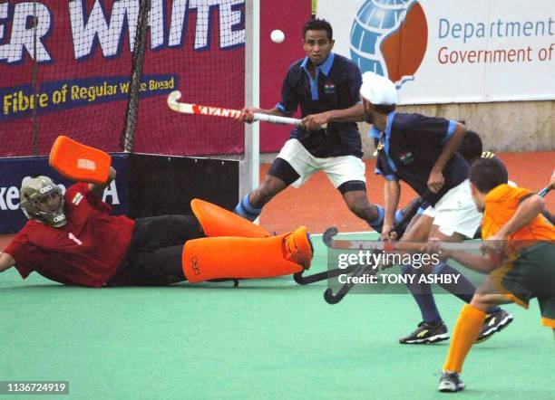 India goalkeeper Devesh Chauhan tries desperately to stop the equalising goal shot by Jamie Dwyer of Australia during the game that Australia won by...