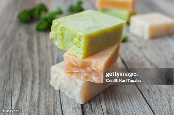 varieties of organic soap on a rustic wooden table - seifenstück stock-fotos und bilder