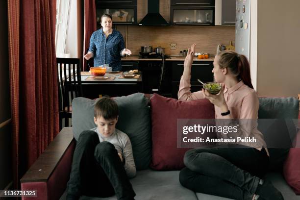 strict middle-aged plus-size mother in casual shirt fighting with adult daughter who refusing to eat at table in kitchen, mother calling children in to dinner - family arguing stock pictures, royalty-free photos & images