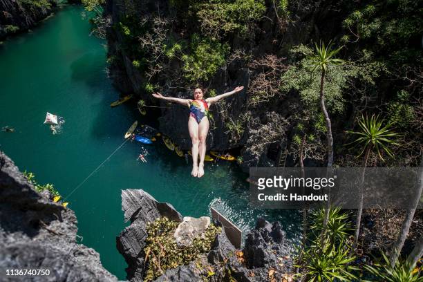 In this handout image provided by Red Bull, Yana Nestsiarava of Belarus dives from a rock precipice at the Small Lagoon on Miniloc Island during the...