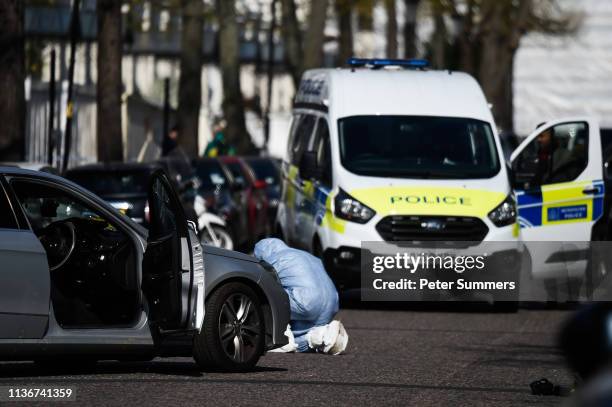 Scenes of crime officers at the scene outside the Ukrainian Embassy where Police opened fire on a vehicle after it crashed into the Ukrainian...