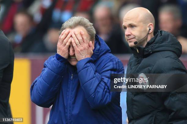 Cardiff City's English manager Neil Warnock reacts on the touchline as fourth official, Anthony Taylor looks on during the English Premier League...