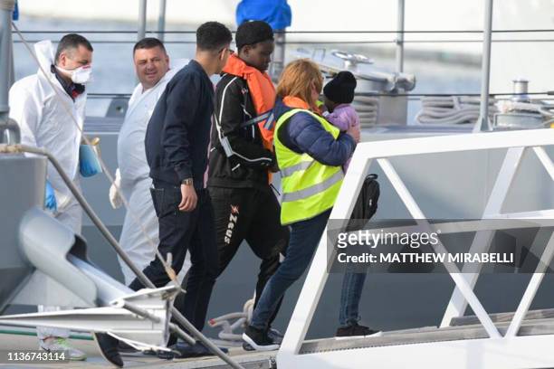 Some of the migrants who were stuck on a ship since their rescue in the Mediterranean 10 days ago, are being welcomed as they disembark in Valletta,...