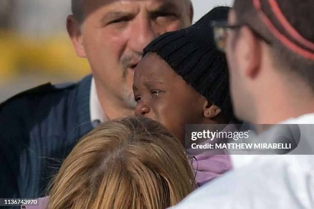 Child with the migrants who were stuck on a ship since their rescue in the Mediterranean 10 days ago, cries as he is being taken care of after...