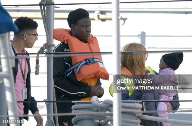 Woman and a child with the migrants who were stuck on a ship since their rescue in the Mediterranean 10 days ago, are being welcomed after...
