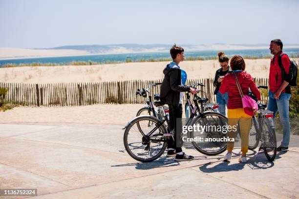 tourists on bicycles exploring cap ferret, france - cap ferret stock pictures, royalty-free photos & images