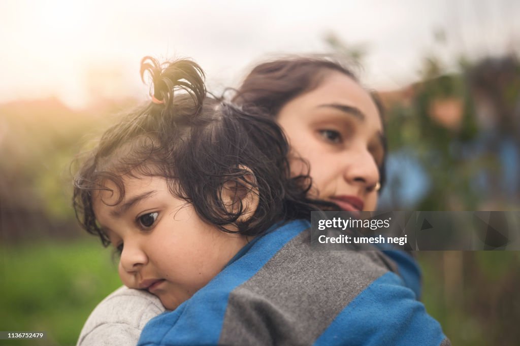Mère triste étreignant sa petite fille à l'extérieur